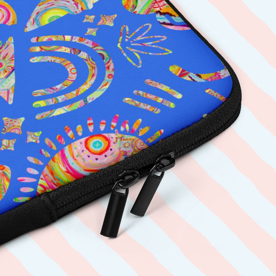 A close up of the 'Blue Summer Sorbet' laptop sleeve by My Favourite Colour of Rainbow, featuring cut outs of Summer Sorbet print in a fun mix of suns, rainbows, ice creams and other abstract shapes, against a striking blue backdrop.