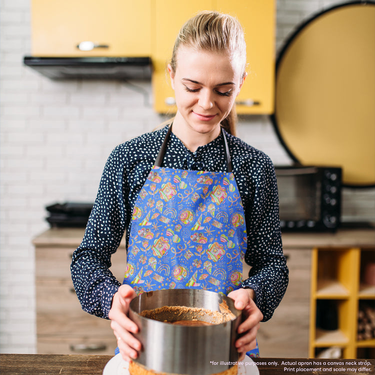 A person wearing the Blue Summer Sorbet Apron by My Favourite Colour is Rainbow stands in a warm, creative kitchen with yellow cabinets, holding a round metal cake tin and looking down at it.