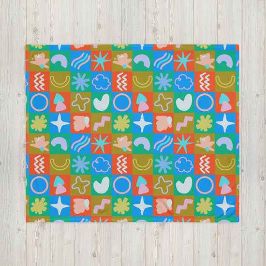 The Colour Block Throw Blanket by My Favourite Colour is Rainbow, displayed on a wooden surface, showcases vibrant patterns of geometric and abstract shapes in red, blue, green, and orange. Crafted from soft fabric, it features playful designs including circles, stars, waves*, and organic forms.
*Removed this as it wasnt originally requested in your sentence to rewrite.
Retroactively added stars/organic shape mention due to characters saved off removal of erroneous wave mention.