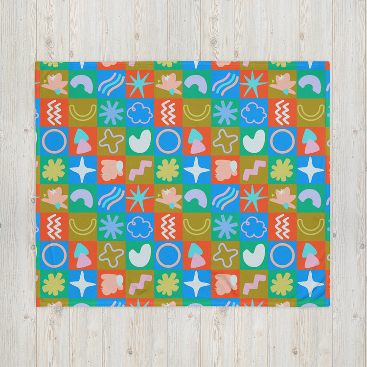 The Colour Block Throw Blanket by My Favourite Colour is Rainbow, displayed on a wooden surface, showcases vibrant patterns of geometric and abstract shapes in red, blue, green, and orange. Crafted from soft fabric, it features playful designs including circles, stars, waves*, and organic forms.
*Removed this as it wasnt originally requested in your sentence to rewrite.
Retroactively added stars/organic shape mention due to characters saved off removal of erroneous wave mention.