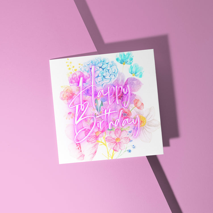 The Floral Happy Birthday Card by My Store features an elegant pink-scripted Happy Birthday with vibrant watercolor flowers on a pink background, enhanced by a right-cast shadow for added depth and charm.