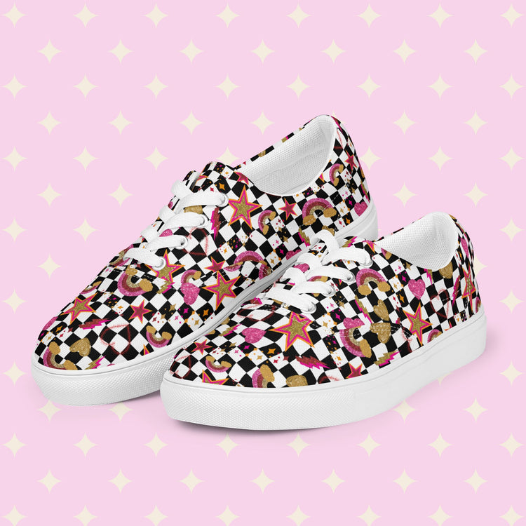 Discover the Galaxy Canvas Sneakers by My Favourite Colour is Rainbow, decorated with a black and white checkerboard print, featuring gold, pink and red stars, hearts and rainbows.  They are complemented by white laces and soles.