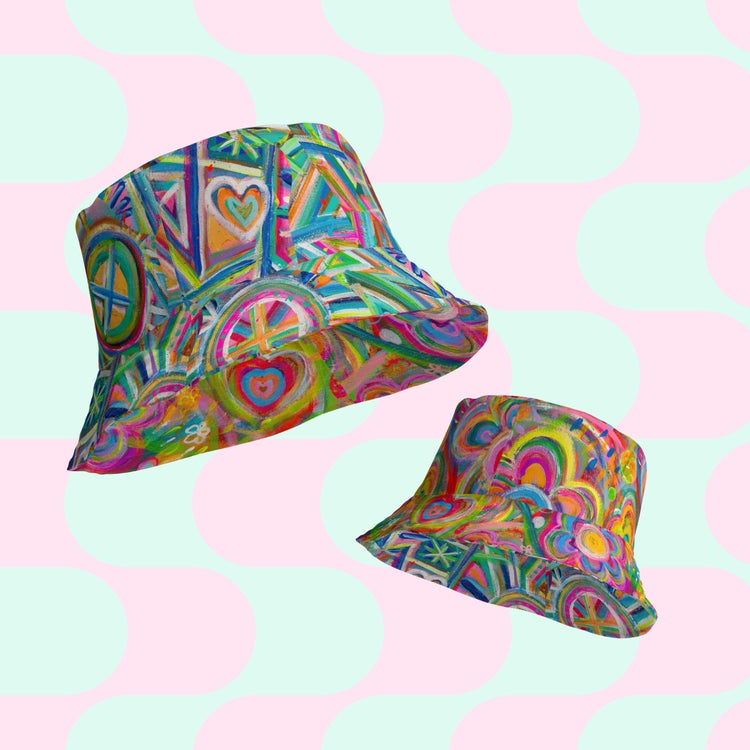 My Favourite Colour is Rainbow offers the Geometric Rainbow/Love in Neon reversible bucket hat with vibrant abstract designs like hearts, circles, and geometric shapes. The playful background features pastel green and pink rounded squares.