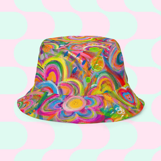 The Geometric Rainbow/Love in Neon Reversible Bucket Hat by My Favourite Colour is Rainbow features vibrant abstract spirals and floral patterns. Multicolored hues swirl over pastel pink circles on a mint green grid, delivering an eye-catching design.
