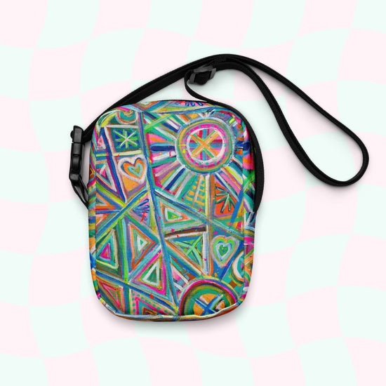 Check out the Geometric Rainbow Mini Crossbody Bag by My Favourite Colour is Rainbow, featuring a vibrant mix of triangles, circles, hearts, and lines in blue, pink, green, and orange. It has adjustable straps and a pink/mint-green checkered background for extra flair.