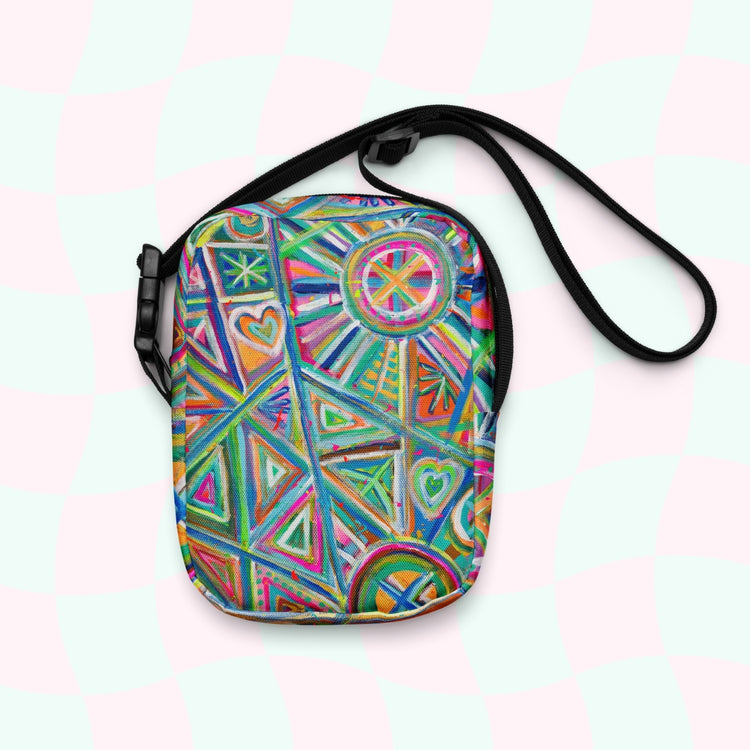 Check out the Geometric Rainbow Mini Crossbody Bag by My Favourite Colour is Rainbow, featuring a vibrant mix of triangles, circles, hearts, and lines in blue, pink, green, and orange. It has adjustable straps and a pink/mint-green checkered background for extra flair.