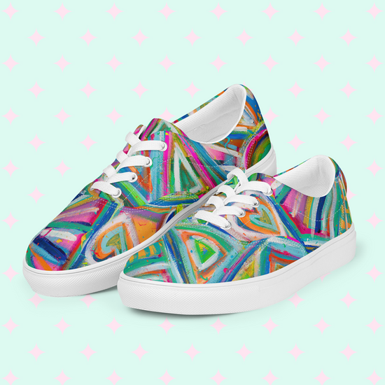 My Favourite Colour is Rainbows Geometric Rainbow Canvas Sneakers feature vibrant blue, green, pink, and orange geometric patterns. They have white soles and laces on a pastel background with pink stars, creating a vividly colorful style.
