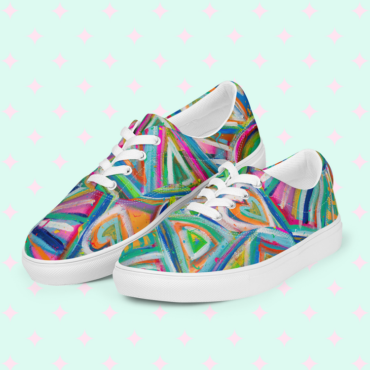 My Favourite Colour is Rainbows Geometric Rainbow Canvas Sneakers feature vibrant blue, green, pink, and orange geometric patterns. They have white soles and laces on a pastel background with pink stars, creating a vividly colorful style.