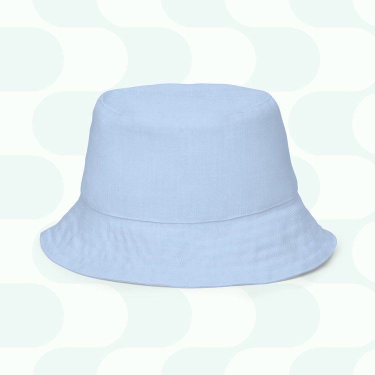 The Green Rainbow Reversible Bucket Hat from My Favourite Colour is Rainbow rests on a patterned background with light gray and white geometric shapes. Perfect for any occasion, this stylish accessory is your new Style BFF, available in multiple sizes for the ideal fit.