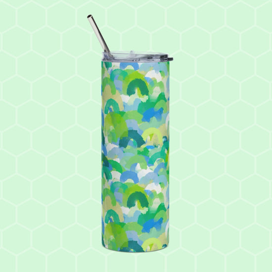 The Green Rainbow Stainless Steel Tumbler by My Favourite Colour is Rainbow features an abstract green, blue, and yellow design on a light green hexagonal background. It includes a transparent lid and a metal straw for reuse.