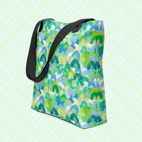 The Green Rainbow Tote Bag by My Favourite Colour is Rainbow is a stylish tote featuring a spacious design with a green and blue watercolour rainbow pattern. It has a black handle.