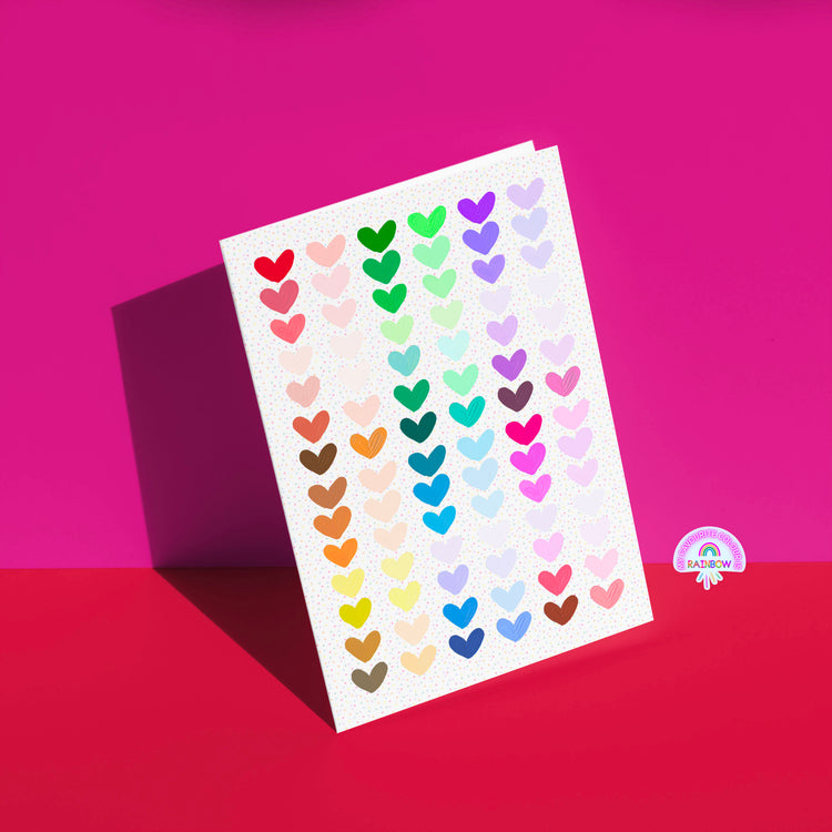 The Heart Attack Greeting Card from My Store features a vibrant heart pattern on a pink and red background, with a rainbow logo in the bottom right corner.