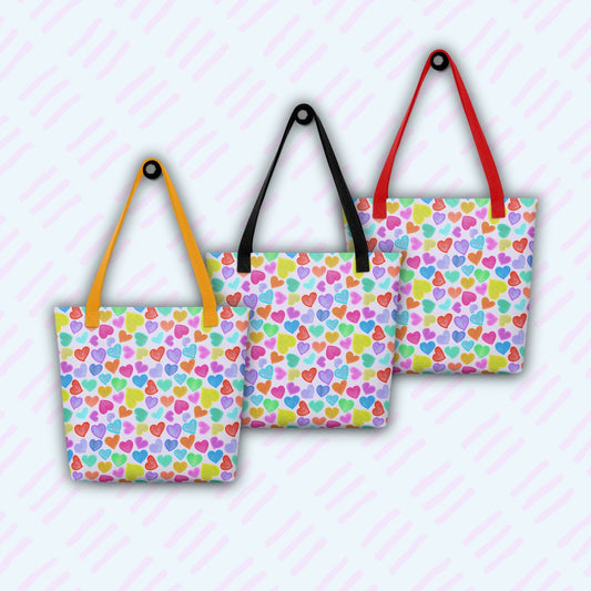 Three Heart Attack Tote Bags by My Favourite Colour is Rainbow, with vibrant patterns, are set against a light background with diagonal pink lines. Each canvas tote has distinct coloured handles—yellow, black, and red.