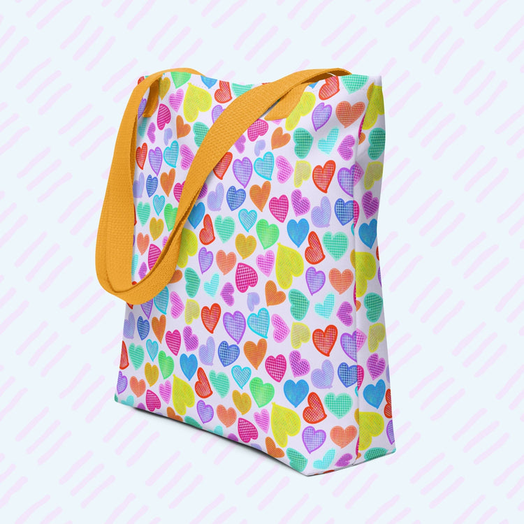 This Heart Attack Tote Bag by My Favourite Colour is Rainbow showcases a lively pattern of multicolored hearts—blue, orange, yellow, pink, and green—on a light background. Equipped with sturdy yellow handles, this stylish and practical canvas tote is perfect for vibrant fashion lovers.