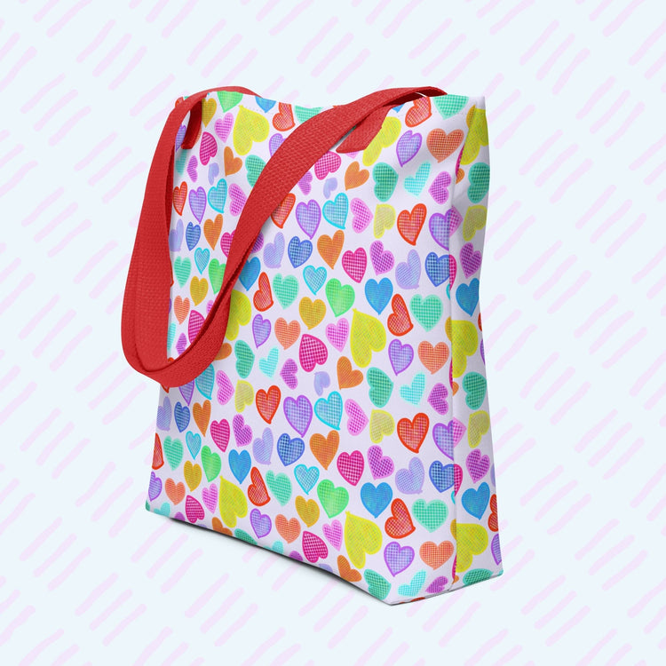 My Favourite Colour is Rainbows Heart Attack Tote Bag features a vibrant pattern of pink, orange, yellow, blue, and purple hearts on a light background.  This version has a red strap.