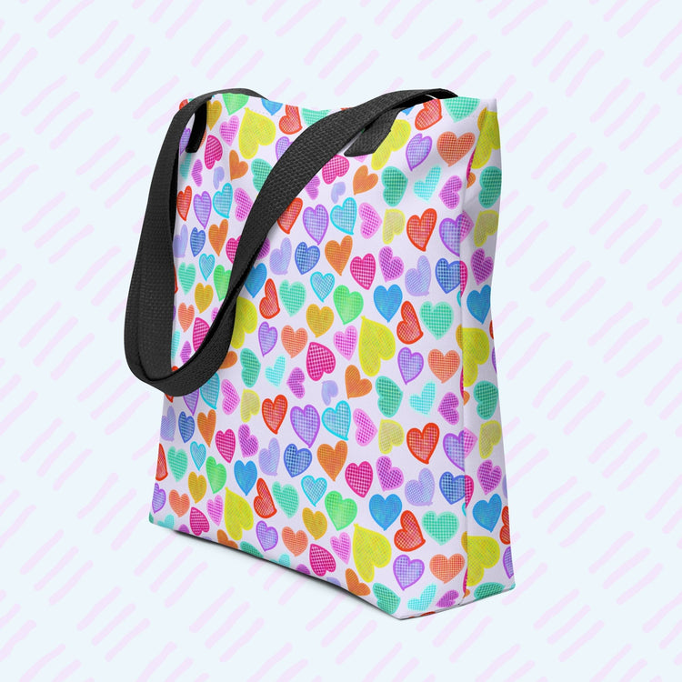 My Favourite Colour is Rainbows Heart Attack Tote Bag features a vibrant pattern of pink, orange, yellow, blue, and purple hearts on a light background.  This version has a black strap.