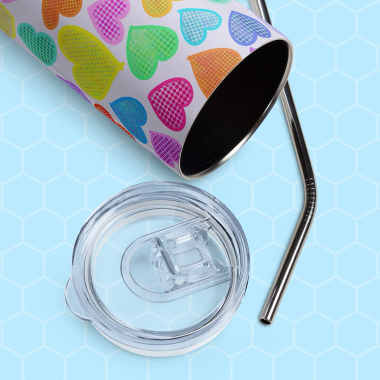 The Heart Attack Stainless Steel Tumbler by My Favourite Colour is Rainbow features multicolored heart patterns on a light blue hexagonal background. The reusable tumbler comes with a clear lid and a metal straw.