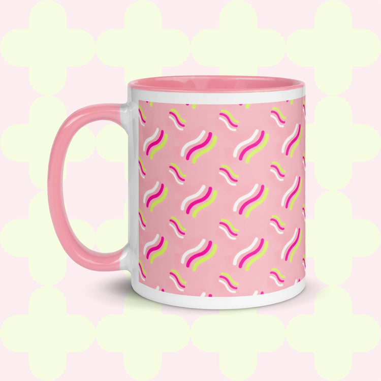 The Iced Vovo Mug by My Favourite Colour is Rainbow features a pink handle on a white and pink base, adorned with wavy lines in pink, yellow, and white against a pink background.
