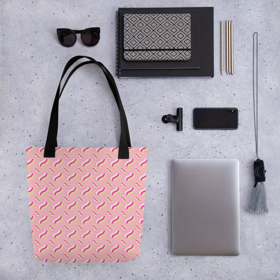 Flat lay of items on a grey surface: a spacious Iced Vovo Tote Bag by My Favourite Colour is Rainbow, black-framed sunglasses, a black-and-white notebook, two pens, a smartphone, a clip, a laptop, and a tassel keychain.