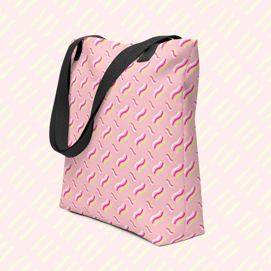 The Iced Vovo Tote Bag by My Favourite Colour is Rainbow is a spacious pink tote featuring an abstract pattern reminiscent of the famous biscuit with white, pink and lime green wavy line patterns. It has black handles and is showcased on a pastel background.