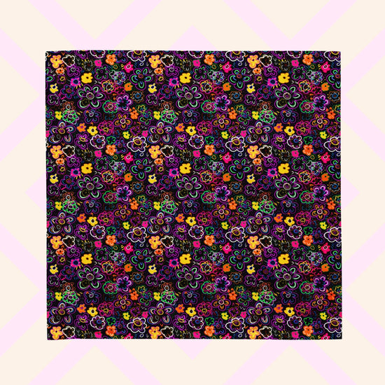 The 'In the Midnight Garden' Bandana by My Favourite Colour is Rainbow features a vibrant floral pattern with pink, orange, yellow, purple, and green flowers on a dark backdrop.