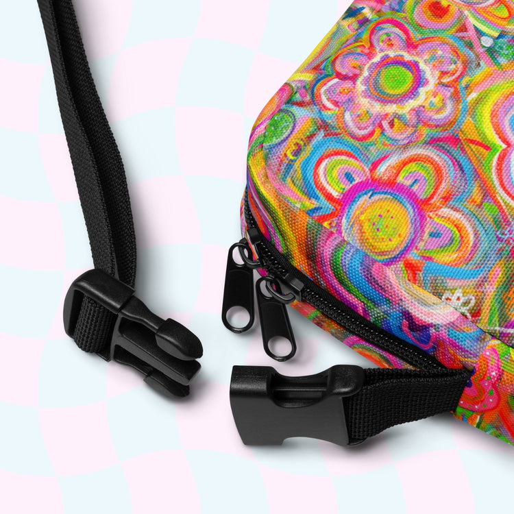 Close-up of the Love in Neon Mini Crossbody Bag by My Favourite Colour is Rainbow, featuring colorful hiking design with adjustable black straps, a durable zipper, and vibrant pink, orange, yellow flowers on a pastel blue and pink checkered background for outdoor charm.