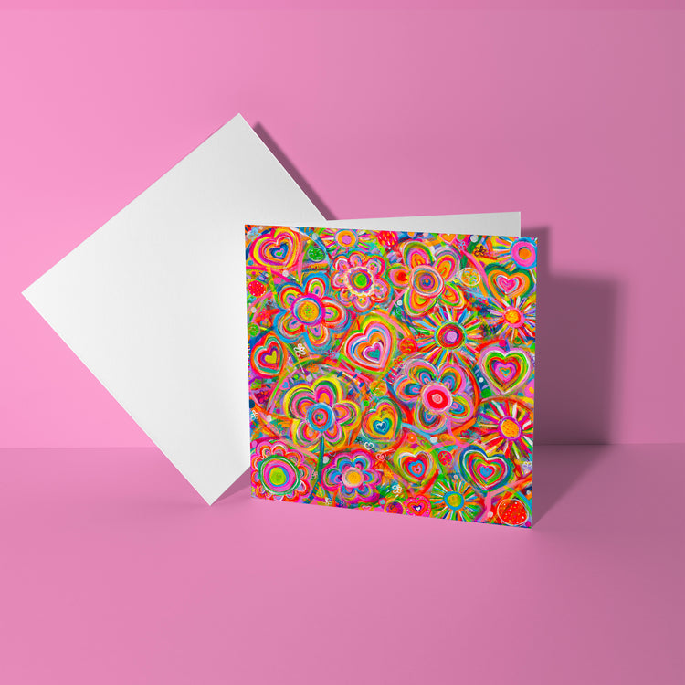 The Love in Neon Greeting Card by My Store features vibrant colors with multicolored floral and heart patterns on the cover, set against a pink background to evoke a sense of love.