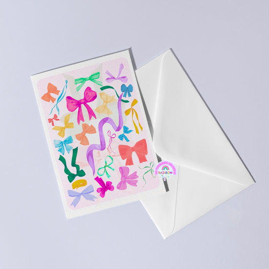 The Multicolour Bow Greeting Card by My Store features vibrant pink, blue, green, and orange bows in various sizes on a versatile card with a white envelope. A circular Rainbow sticker completes this stylish birthday card.