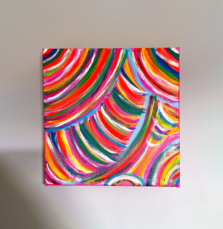 The Neon Candy Floss Original Painting by My Store showcases vibrant pink, orange, green, blue, and yellow curved stripes on a square canvas. This dynamic rainbow abstract features colorful acrylic arcs against a plain wall background.