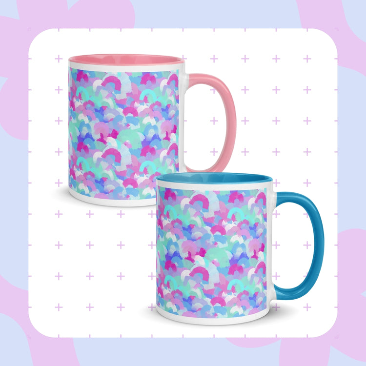 Two Pastel Rainbow Mugs by My Favourite Colour is Rainbow, featuring soft watercolour rainbows in pink, blue, aqua and white.  One features a pink handle and interior, and the other has blue.