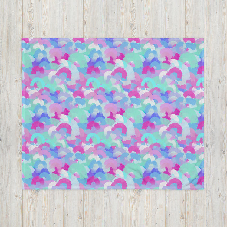 The Pastel Rainbow Throw Blanket by My Favourite Colour is Rainbow features a vibrant abstract design with overlapping pastel blue, pink, purple, and white brush strokes on a wooden background. Resembling arches or waves, it adds a cozy touch to any space.
.
