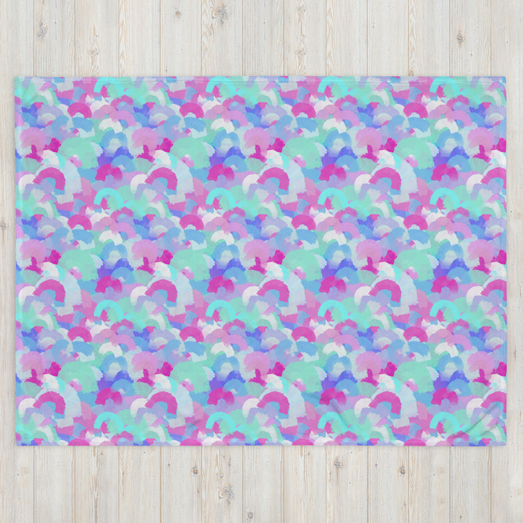 A cozy space is adorned with a vibrant design of overlapping pastel semicircles in pink, blue, purple, and green, reminiscent of the Pastel Rainbow Throw Blanket by My Favourite Colour is Rainbow against a light wooden backdrop.