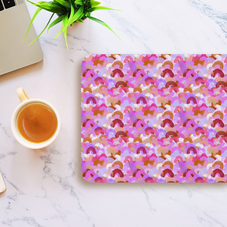 A Pink Rainbow Mouse Pad by My Favourite Colour is Rainbow sits on a marble surface next to a cup of coffee and part of a laptop, with a small green plant nearby.
