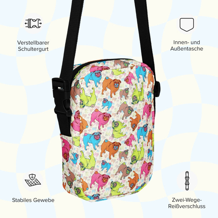 An infographic highlighting features of the Pugalicious Mini Crossbody Bag by My Favourite Colour is Rainbow: adjustable shoulder strap, inside and outside pocket, sturdy canvas fabric and a two-way zipper.