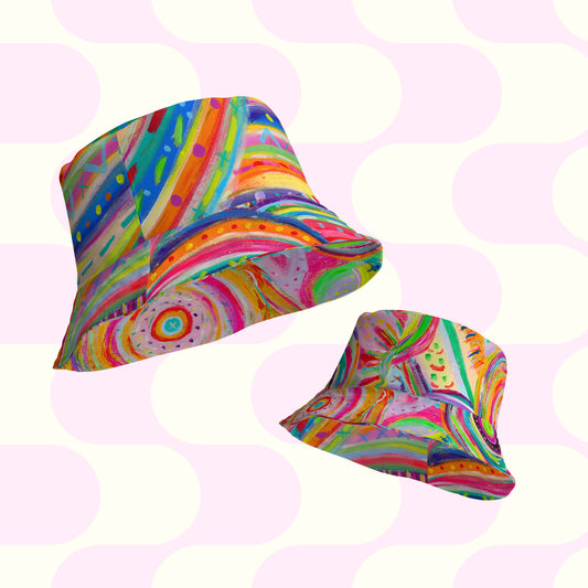 Two reversible bucket hats, The Rainbow Connection/Summer Sorbet by My Favourite Colour is Rainbow, feature abstract swirls and dots in vibrant rainbow hues on a pastel pink and white background, perfect for adding a playful and artistic touch to your style.
