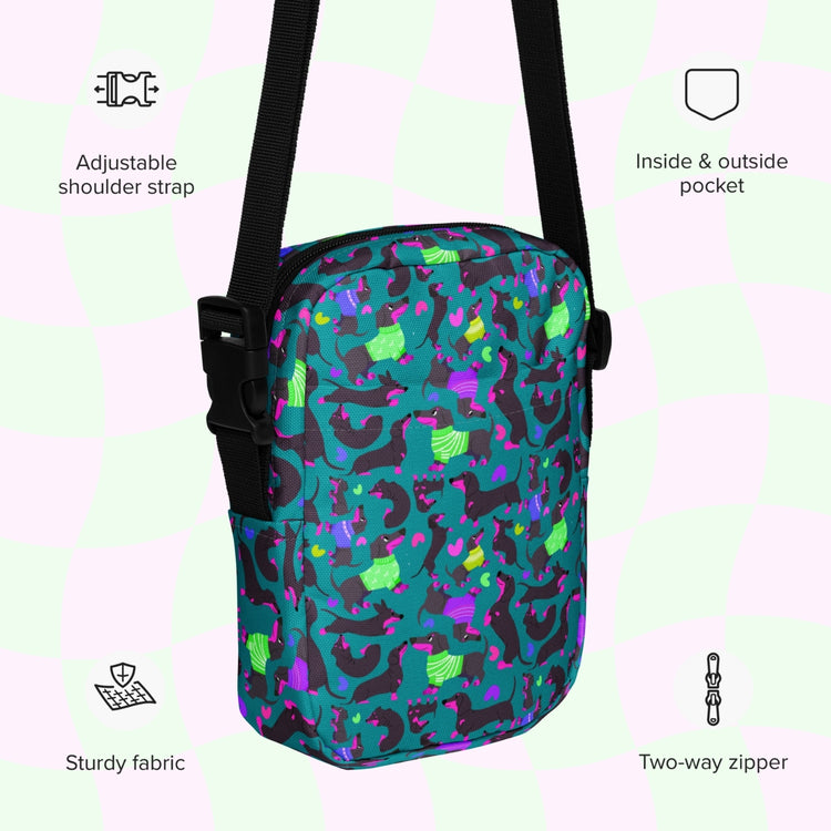 An infographic highlighting features of the Silly Sausages Mini Crossbody Bag by My Favourite Colour is Rainbow: adjustable shoulder strap, inside and outside pocket, sturdy canvas fabric and a two-way zipper.