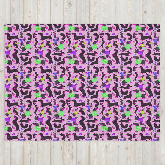 The Silly Sausages Throw Blanket - Pink by My Favourite Colour is Rainbow features a lively, playful pattern with abstract cats, dogs, and horses in black, green, blue, and purple on a pink background. This whimsical design adds charm to any space.