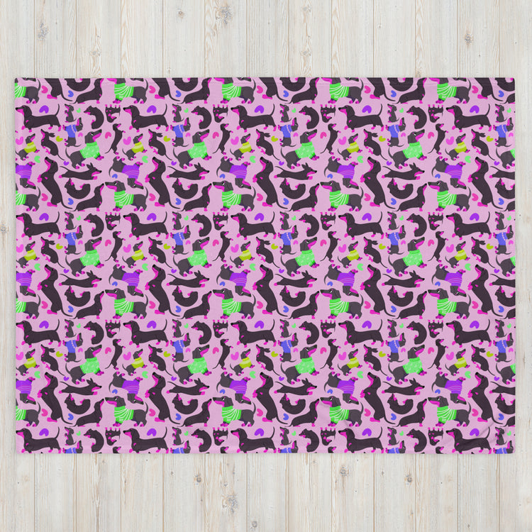 The Silly Sausages Throw Blanket - Pink by My Favourite Colour is Rainbow features a lively, playful pattern with abstract cats, dogs, and horses in black, green, blue, and purple on a pink background. This whimsical design adds charm to any space.