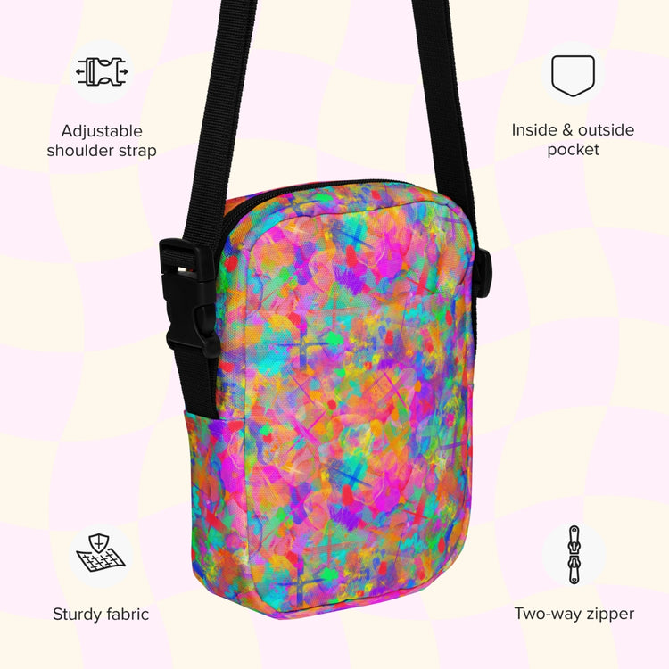 An infographic highlighting features of the Splotches and Crosses Mini Crossbody Bag by My Favourite Colour is Rainbow: adjustable shoulder strap, inside and outside pocket, sturdy canvas fabric and a two-way zipper.