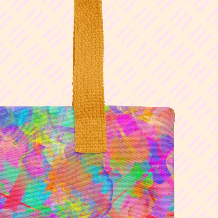 A close-up of the Splotches and Crosses Tote Bag by My Favourite Colour is Rainbow showing the sturdy yellow strap. 
 The bag features a vibrant abstract design in pink, blue, green, and yellow.