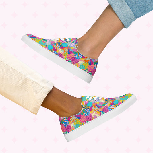 Two pairs of legs showcase vibrant style with Squiggs and Stripes Canvas Sneakers by My Favourite Colour is Rainbow. One wears light cream pants, the other rolled-up denim jeans, set against a pink star pattern background that complements the lively sneakers colorful design.