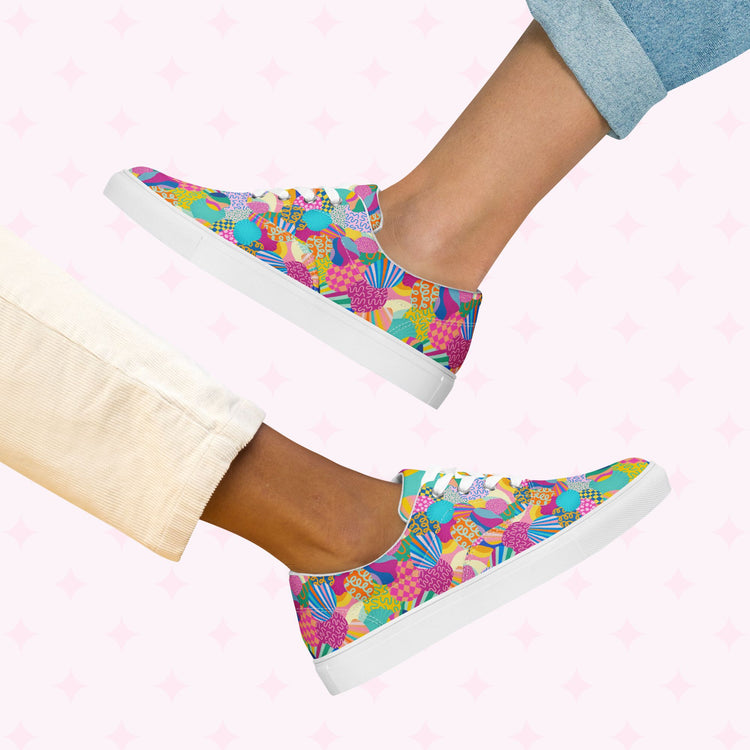 Two pairs of legs showcase vibrant style with Squiggs and Stripes Canvas Sneakers by My Favourite Colour is Rainbow. One wears light cream pants, the other rolled-up denim jeans, set against a pink star pattern background that complements the lively sneakers colorful design.