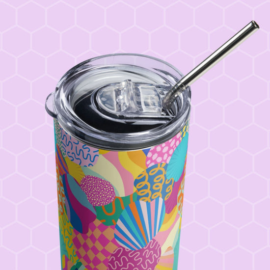 The Squiggs and Stripes Stainless Steel Tumbler by My Favourite Colour is Rainbow features colorful abstract patterns, a metal straw, and a transparent lid on a light purple hexagonal background.