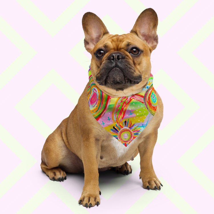 A brown French Bulldog sits proudly wearing the Summer Sorbet Bandana by My Favourite Colour is Rainbow. The bandana features a colourful abstract design with swirling circles, geometric shapes and doodle-like details in hues of pink, yellow, blue, green, orange, and red.