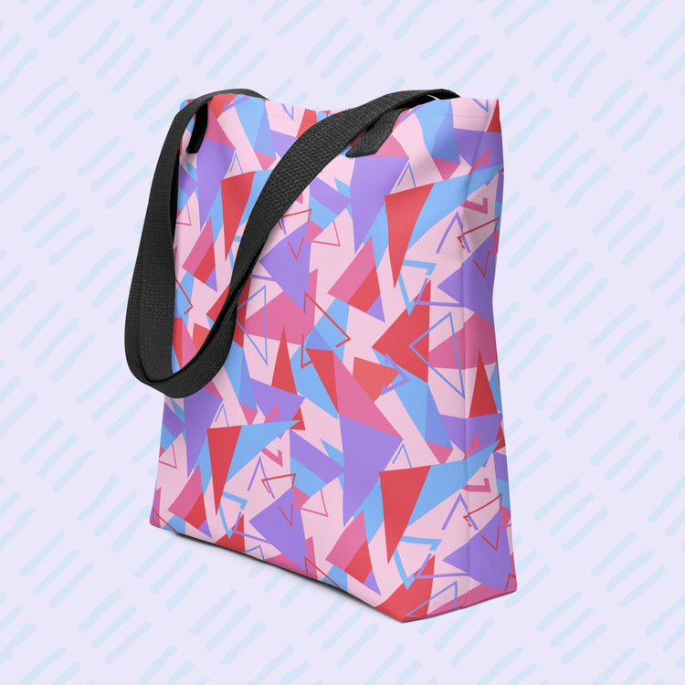 The Tri the Angle Tote Bag by My Favourite Colour is Rainbow features red, purple, blue, and pink triangle patterns with a black handle.