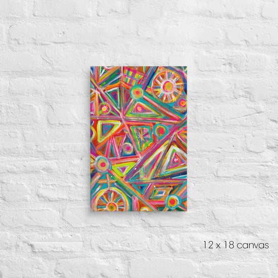 The Tropical Geometry Canvas Artwork by My Favourite Colour is Rainbow features vibrant geometric patterns of triangles, circles, and lines in lively colors on a 12x18 canvas, beautifully displayed against a white brick wall.