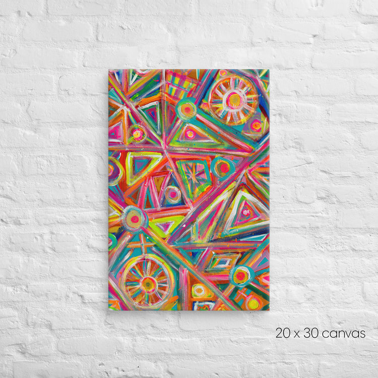 The Tropical Geometry Canvas Artwork by My Favourite Colour is Rainbow decorates a white brick wall with vibrant geometric patterns, featuring triangles, circles, and lines in pink, orange, green, and blue hues. The reproduction measures 20 x 30 inches.
