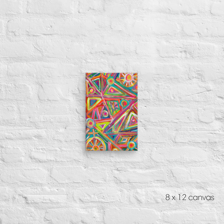 The Tropical Geometry Canvas Artwork by My Favourite Colour is Rainbow is a vibrant abstract piece showcasing triangles and circles in pink, blue, and yellow. Displayed on a white brick wall, this artwork measures 8 x 12 inches with dimensions noted in the bottom right corner.