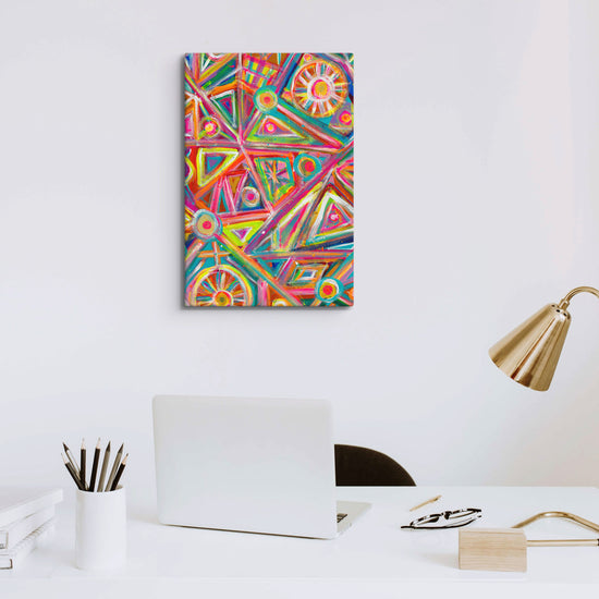 A modern office features a white desk with an open laptop and stationery. On the right is a sleek gold lamp, while Tropical Geometry Canvas Artwork by My Favourite Colour is Rainbow highlights vibrant geometric patterns above the desk.
