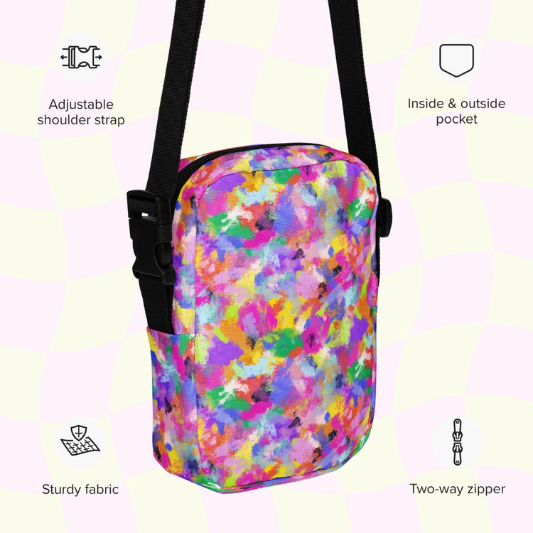 An infographic highlighting features of the Watercolour Rainbow Mini Crossbody Bag by My Favourite Colour is Rainbow: adjustable shoulder strap, inside and outside pocket, sturdy canvas fabric and a two-way zipper.